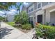 Well-manicured front exterior of a lovely townhome with lush landscaping, walkway, and welcoming black front door at 8856 Christie Dr # 0, Largo, FL 33771