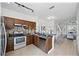 Open kitchen featuring an island with stainless steel appliances, dark wood cabinets, and natural light at 8856 Christie Dr # 0, Largo, FL 33771