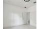 A bright, all-white bedroom with a doorway to an adjacent room shows modern interior design at 3009 E 148Th Ave # B, Lutz, FL 33559
