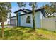 Modern home with a light blue exterior, a grey garage door, and minimalist landscaping at 3009 E 148Th Ave # B, Lutz, FL 33559