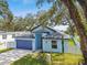 Charming exterior view of the house featuring a blue garage door and light blue paint at 3009 E 148Th Ave # B, Lutz, FL 33559