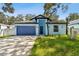 Charming single-story home featuring a blue exterior, well-maintained lawn, and an attached garage at 3009 E 148Th Ave # B, Lutz, FL 33559