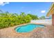 Inviting pool surrounded by lush tropical plants and a brick patio at 10308 Sandpiper W Rd, Bradenton, FL 34209