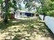 Large backyard featuring mature trees, white fencing, and plenty of room for outdoor activities at 11592 110Th Ter, Seminole, FL 33778