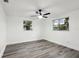 Airy bedroom with wood-look flooring, modern ceiling fan, and two windows at 11592 110Th Ter, Seminole, FL 33778