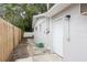 Side exterior featuring a white door, brick paver walkway, and a well-maintained yard with a fence at 11592 110Th Ter, Seminole, FL 33778