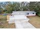 Well-maintained home featuring a two-car garage, mature trees, green grass, and a charming, landscaped front yard at 11592 110Th Ter, Seminole, FL 33778
