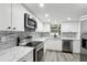 Modern kitchen featuring stainless steel appliances, white cabinets and white quartz countertops and gray backsplash at 11592 110Th Ter, Seminole, FL 33778