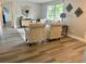 Bright living room with wood-look flooring, comfortable seating, and large window showcasing the outdoor view at 11592 110Th Ter, Seminole, FL 33778