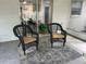 Outdoor patio features two wicker chairs with tan cushions, a plant stand, and a view of the dining area at 11592 110Th Ter, Seminole, FL 33778