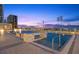 Evening view of the pool area, featuring relaxing lounge chairs and a serene cityscape at 301 1St S St # 2006, St Petersburg, FL 33701