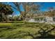 Lush backyard featuring mature trees and ample space for outdoor entertaining at 402 Pineapple St, Tarpon Springs, FL 34689