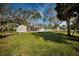 Spacious backyard with mature trees, storage shed, and potential for landscaping at 402 Pineapple St, Tarpon Springs, FL 34689