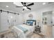 Bright bedroom featuring a barn-door bathroom, ceiling fan, and stylish furnishings at 402 Pineapple St, Tarpon Springs, FL 34689
