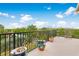 Spacious balcony with lush landscaping and colorful potted plants overlooks a serene lake at 8731 Betty St, Port Richey, FL 34668