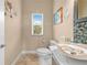 Well-appointed half bathroom with stylish sink, toilet, decor, and natural light for guests' convenience at 8731 Betty St, Port Richey, FL 34668