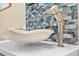 Elegant bathroom sink featuring designer fixtures, stone counter, and stylish tile backsplash at 8731 Betty St, Port Richey, FL 34668