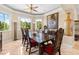 Formal dining room with large windows, decorative vases, and an ornate dark wood table with red cushioned chairs at 8731 Betty St, Port Richey, FL 34668
