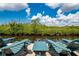 Relaxing waterfront view with two Adirondack chairs and table on a wooden dock overlooking lush greenery at 8731 Betty St, Port Richey, FL 34668