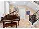 Grand foyer showcasing a staircase with wrought iron railing and a Steinway piano, creating a sophisticated ambiance at 8731 Betty St, Port Richey, FL 34668
