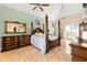 Elegant main bedroom featuring a four-poster bed, ceiling fan, and tiled floors and ensuite bathroom access at 8731 Betty St, Port Richey, FL 34668