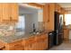 Charming kitchen showcases a granite countertop, stainless steel appliances, stylish wooden trim and ample cabinet space at 9705 45Th N Way, Pinellas Park, FL 33782