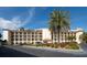 Exterior view of the condominium building with multiple floors, palm trees, and ample parking at 19029 Us Highway 19 N # 26-304, Clearwater, FL 33764
