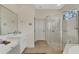 Bright bathroom featuring a glass-enclosed shower, white cabinetry, and a large mirror at 2850 Deer Run, Tarpon Springs, FL 34688