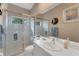 Clean bathroom featuring a glass-door shower, white vanity, and a large mirror with sconces at 2850 Deer Run, Tarpon Springs, FL 34688