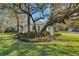 Charming single Gathering home featuring a sprawling front yard with mature trees and lush landscaping at 2850 Deer Run, Tarpon Springs, FL 34688
