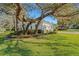 Well-maintained home exterior with lush landscaping and mature trees in a quiet neighborhood at 2850 Deer Run, Tarpon Springs, FL 34688
