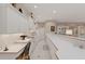 A well-lit kitchen features white cabinets, tiled backsplash, long countertops, and modern appliances at 2850 Deer Run, Tarpon Springs, FL 34688