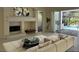 Bright living room featuring a fireplace and views of the outdoor pool area at 2850 Deer Run, Tarpon Springs, FL 34688