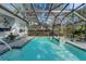 A luxurious pool with an overhead screened enclosure, featuring fountain features and a spa at 2850 Deer Run, Tarpon Springs, FL 34688