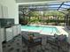 Relaxing outdoor space with a screened pool, spa, and a convenient poolside kitchenette at 2850 Deer Run, Tarpon Springs, FL 34688
