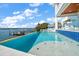 Stunning infinity pool overlooking the waterfront, complete with a tanning platform and lush landscaping at 477 20Th Ave, Indian Rocks Beach, FL 33785