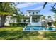 Relaxing pool, with ample green space, surrounded by lush landscaping and a well-maintained two-story home at 5038 W Dickens Ave, Tampa, FL 33629