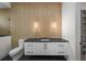 Modern bathroom with a floating vanity, wooden accent wall, and unique lighting fixtures at 5038 W Dickens Ave, Tampa, FL 33629