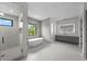 Bright bathroom featuring a soaking tub, glass shower, and double vanity at 5038 W Dickens Ave, Tampa, FL 33629