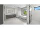 Modern bathroom with double vanities, a freestanding tub, and a glass-enclosed shower, creating a luxurious space at 5038 W Dickens Ave, Tampa, FL 33629