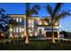 Contemporary home with manicured lawn, striking front facade, illuminated by landscape and architectural lighting at 5038 W Dickens Ave, Tampa, FL 33629