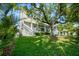 Beautiful, modern house featuring well manicured green lawn and a mature shade tree at 5038 W Dickens Ave, Tampa, FL 33629