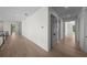 Long hallway with light hardwood floors and gray doors leading to various rooms at 5038 W Dickens Ave, Tampa, FL 33629