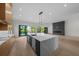 Open concept kitchen featuring a large marble island, modern lighting, and floor-to-ceiling sliding doors to the backyard at 5038 W Dickens Ave, Tampa, FL 33629