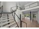 Grand staircase with modern railings overlooks an open living area and backyard through sliding glass doors at 5038 W Dickens Ave, Tampa, FL 33629