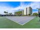 Well-maintained tennis court with lush green surroundings in a residential community at 670 Island Way # 500, Clearwater Beach, FL 33767