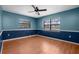 Cozy bedroom with wood floors, two windows, and a ceiling fan at 705 Whiteway Dr, Brooksville, FL 34601
