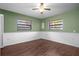 Bright bedroom with wood floors, two windows, and a ceiling fan at 705 Whiteway Dr, Brooksville, FL 34601