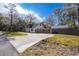 Two-story home showcasing a large front yard, driveway, and lush landscaping for curb appeal at 705 Whiteway Dr, Brooksville, FL 34601