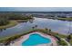 Aerial view of community pool area with ample seating and surrounded by lush greenery near a lake at 12940 Brookside Moss Dr, Riverview, FL 33579